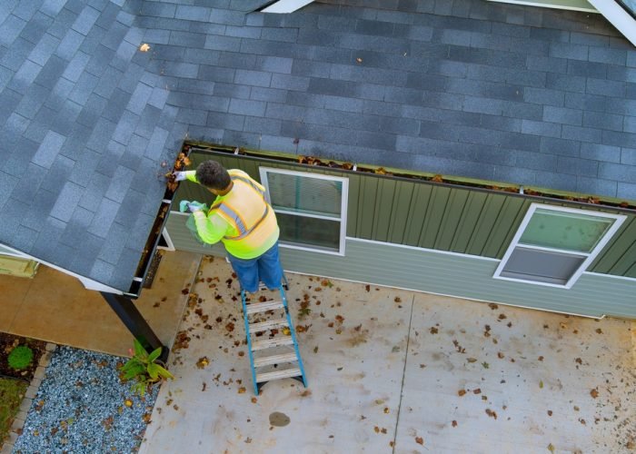 This,Worker,Is,Cleaning,Out,Clogged,Roof,Gutter,Drains,That